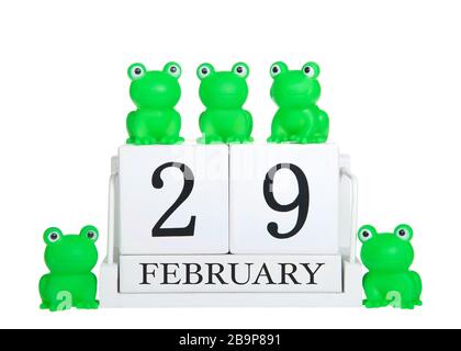 White calendar blocks February 29 isolated on white background with generic green frogs on and around calendar. Leap Year theme Stock Photo