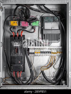 Close-up of an old white dirty control panel, kilowatt hour electricity meter, power supply meter, hour symbol and measuring dial install on pole Stock Photo