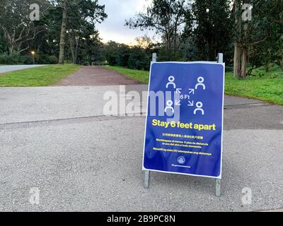 San Francisco, California March 23, 2020: Stay 6 feet apart social distancing guidelines for coronavirus COVID-19 on signboard in front of trail path Stock Photo