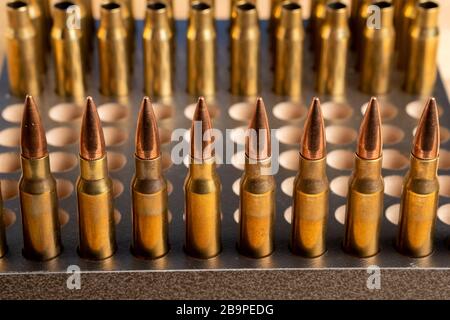 Production of cartridges for a rifle, reload. Empty shells and ammunition. Close up Stock Photo