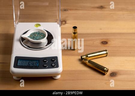 Production of cartridges for a rifle, reload. Empty shells and gunpowder scales Stock Photo