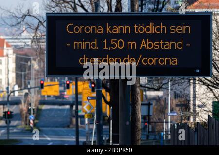 25 March 2020, Saxony, Dresden: On a digital scoreboard in Dresden's university quarter it says 'Corona can be deadly - at least 1.50 metres away'. To contain the corona virus, Saxony now bans all accumulations of three or more people in public places. Photo: Robert Michael/dpa-Zentralbild/dpa Stock Photo