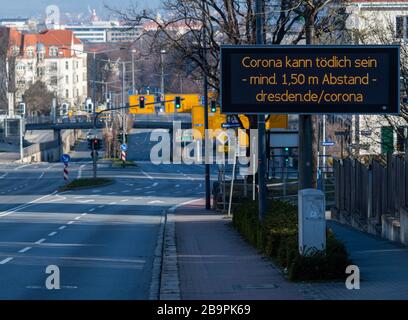 25 March 2020, Saxony, Dresden: On a digital scoreboard in Dresden's university quarter it says 'Corona can be deadly - at least 1.50 metres away'. To contain the corona virus, Saxony now bans all accumulations of three or more people in public. Photo: Robert Michael/dpa-Zentralbild/dpa Stock Photo