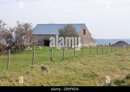 A large lone stone built building with a new roof situated on a hill top overlooking Bridgend in South Wales. Stock Photo
