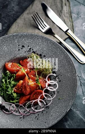 Tuna tagliata in vegetables stewed carrots and peppers, Beautiful serving, traditional Italian cuisine, gray background, copy space. food concept. Stock Photo