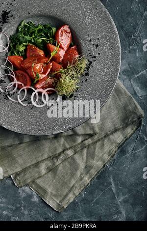 Tuna tagliata in vegetables stewed carrots and peppers, Beautiful serving, traditional Italian cuisine, gray background, copy space. food concept. Stock Photo