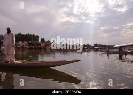 A man standing on Shikara in Kashmir Srinagar Dal Lake in India Stock Photo