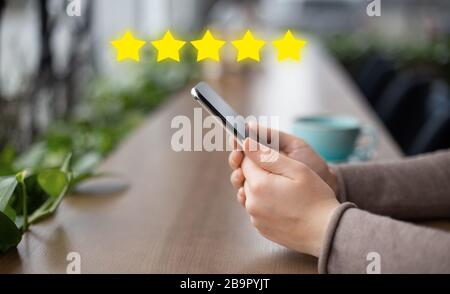 Hand of woman using smartphone on wooden table Stock Photo