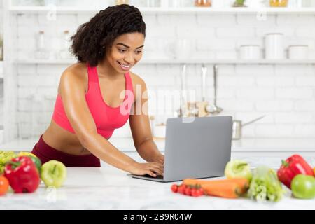 Black girl using laptop searching new recipes Stock Photo