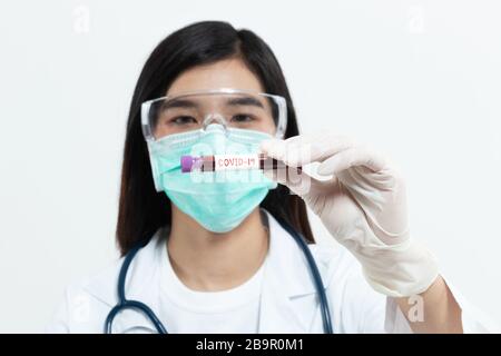 Coronavirus blood sample. Asian doctor holding test tube with blood for covid-19 analyzing. laboratory analyzing for testing and invent drug and vacci Stock Photo