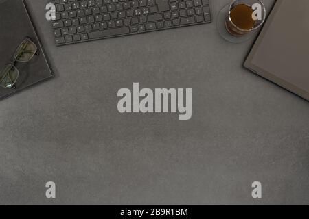 Top view of contemporary black concrete office desk with computer and supplies Stock Photo