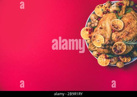 Roasted chicken with oranges, rosemary and cranberries on plate over concrete background. Traditional Thanksgiving or Friendsgiving holiday celebratio Stock Photo