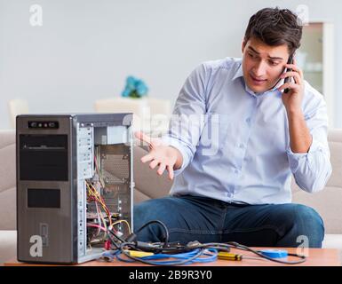 The angry customer trying to repair computer with phone support Stock Photo