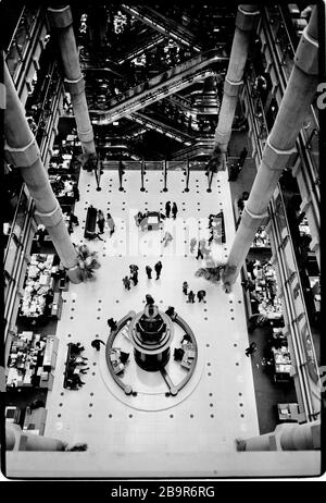 City of London. Lloyd’s of London Insurance trading floor photographed with permission in 1988. Lloyd's of London, generally known simply as Lloyd's, is an insurance and reinsurance market located in London, United Kingdom. Unlike most of its competitors in the industry, it is not an insurance company; rather, Lloyd's is a corporate body governed by the Lloyd's Act 1871 and subsequent Acts of Parliament. It operates as a partially-mutualised marketplace within which multiple financial backers, grouped in syndicates, come together to pool and spread risk. These underwriters, or 'members', are a Stock Photo