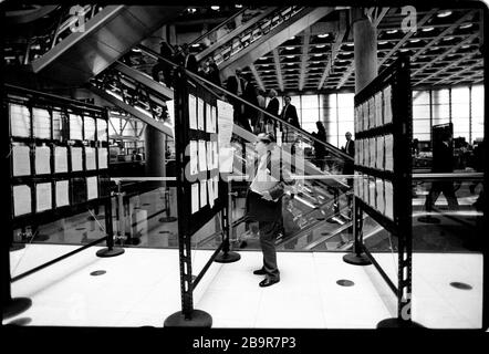 City of London. Lloyd’s of London Insurance trading floor photographed with permission in 1988. Lloyd's of London, generally known simply as Lloyd's, is an insurance and reinsurance market located in London, United Kingdom. Unlike most of its competitors in the industry, it is not an insurance company; rather, Lloyd's is a corporate body governed by the Lloyd's Act 1871 and subsequent Acts of Parliament. It operates as a partially-mutualised marketplace within which multiple financial backers, grouped in syndicates, come together to pool and spread risk. These underwriters, or 'members', are a Stock Photo