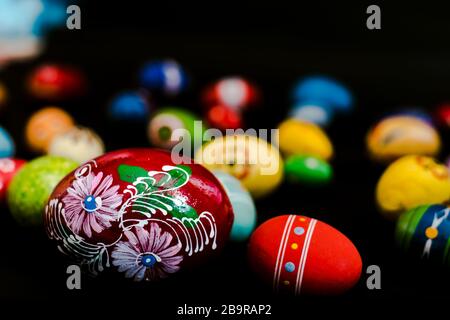multicolored wooden eggs on black background Stock Photo