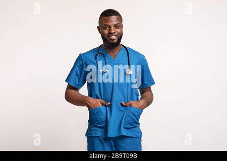 Black guy intern with hands in pockets over white Stock Photo