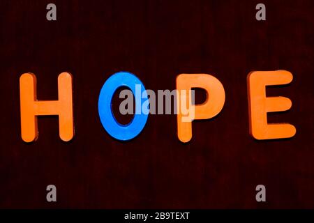 Hope word written with different colored letter blocks arranged on a dark background Stock Photo