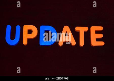 Update word written with different colored letter blocks arranged on a dark background Stock Photo