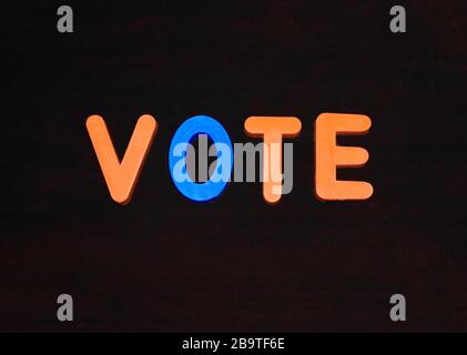 Vote word written with different colored letter blocks arranged on a dark background
