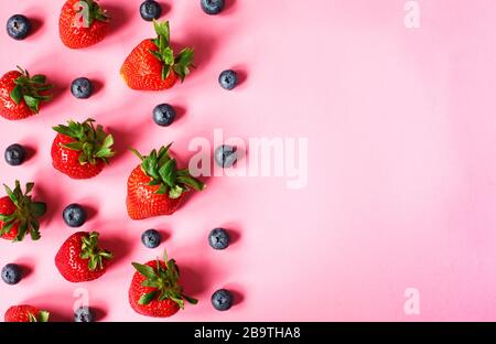 Strawberries and blueberries on pink background. Strawberry and blueberry pattern. Stock Photo