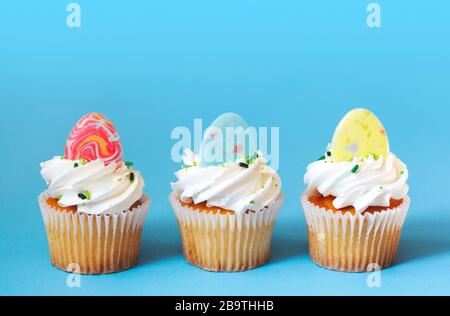 Easter vanilla cupcakes on blue background Stock Photo
