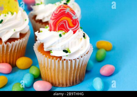 Easter vanilla cupcakes on blue background, copy space Stock Photo