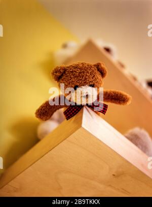 Teddy bear on high shelf Stock Photo