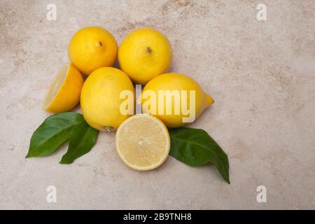 Lemons against a light background with leaves Stock Photo