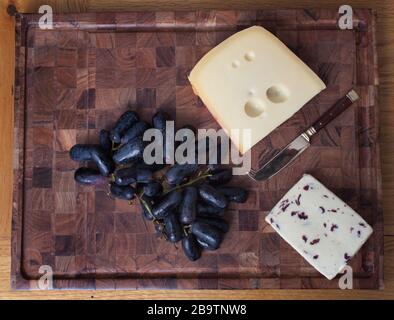 British Wensleydale and Norwegian Jarlsberg cheese with long black sweet grapes Stock Photo