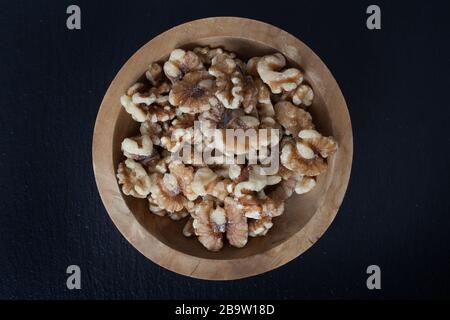 Walnuts in a small wooden bowl Stock Photo
