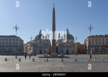 ROME, ITALY - 12 March 2020: Tourists walk across Piazza del Popolo in Rome, Italy. Following the coronavirus pandemic, a nationwide lockdown has empt Stock Photo