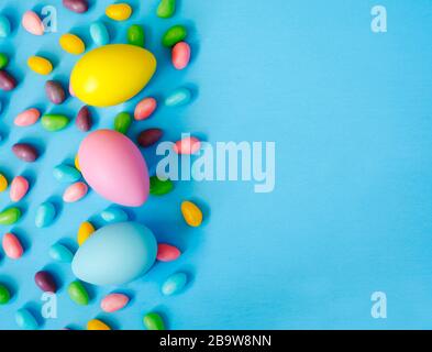 Easter decoration eggs and candy on blue background. Easter background, copy space Stock Photo