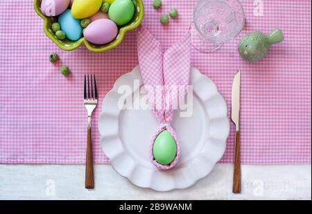 Festive Easter table setting with napkin Easter Bunny, top view. Stock Photo