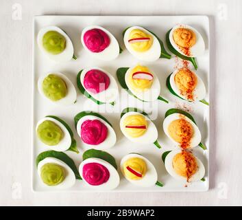A plate of deviled eggs on dark grey stone background, top view Stock Photo