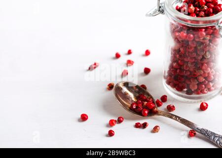 Pink peppers in a glass jar, copy space Stock Photo