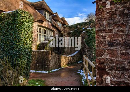 Cockington Mill Cottage with water wheel, in Cockington country park, Torquay, Devon, UK. March 2018. Stock Photo