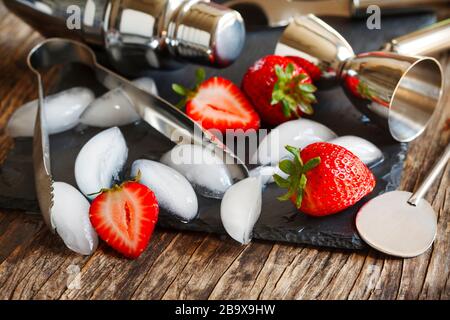 Set of bar accessories and ingredients for making a cocktails arranged on a wooden background with black board for copy space Stock Photo
