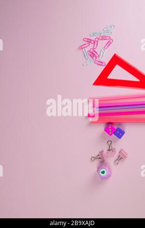 Multi-colored red and pinc pencils rulers, pens, pencils and scissors and stationery stand on a pink background Stock Photo