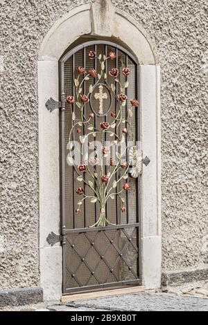 Vertical image of an ornate chapel gate adorned with iron rose vine