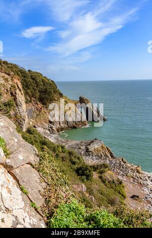 Sea arch known as London Bridge on the cliffs around Torquay, with view over Torbay beyond. Torquay, Devon, UK. March 2018. Stock Photo