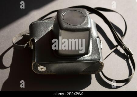 Vintage film photo camera on the dark sunny background. Combination of light and shadows Stock Photo