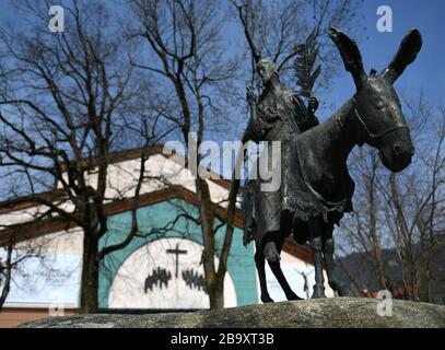 Oberammergau, Germany. 24th Mar, 2020. Jesus as he rides on the donkey stands as a statue in front of the Passion Theatre. After the cancellation of the Oberammergau Passion Plays, the animal actors have been released from their roles for the time being. Credit: Angelika Warmuth/dpa/Alamy Live News Stock Photo