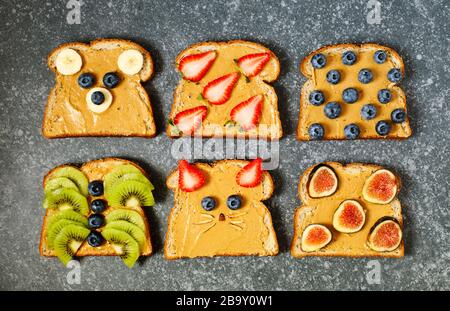 Nut butter and fruits vegan toasts. Funny animal faces toasts Stock Photo