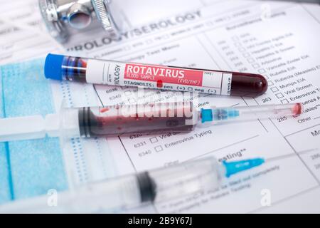 Fictional Blood samples with infected Rotavirus, with mask, syringe and lab report. Stock Photo