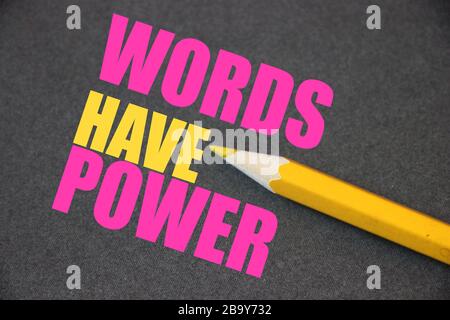 The phrase Words Have Power written with yellow pencil on texturized dark grey paper. Copywriting pir concept Stock Photo