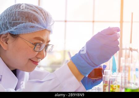 An Asian female scientist is researching a chemical formula in a lab.