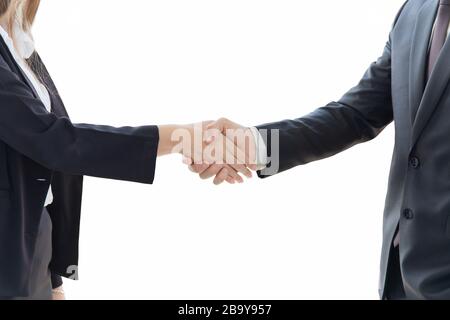 Two young business men and women are neatly dressed in a suit and tie, standing hand in hand, showing separate business symbols on a white background. Stock Photo