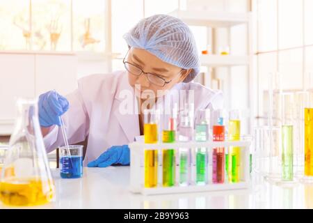 An Asian female scientist is researching a chemical formula in a lab.