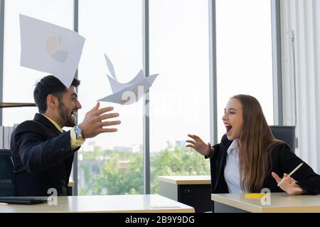 Two young businessmen, men and women, who showed great joy at the office with smiles and happiness. Stock Photo
